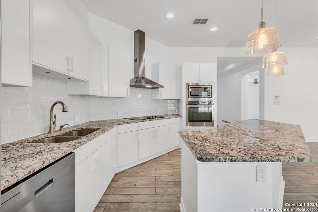 1303 Summerfield San Antonio, TX 78258 - Photo 7 of 27 a kitchen with stainless steel appliances granite countertop a sink stove and refrigerator