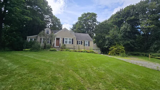 a front view of a house with a yard and trees