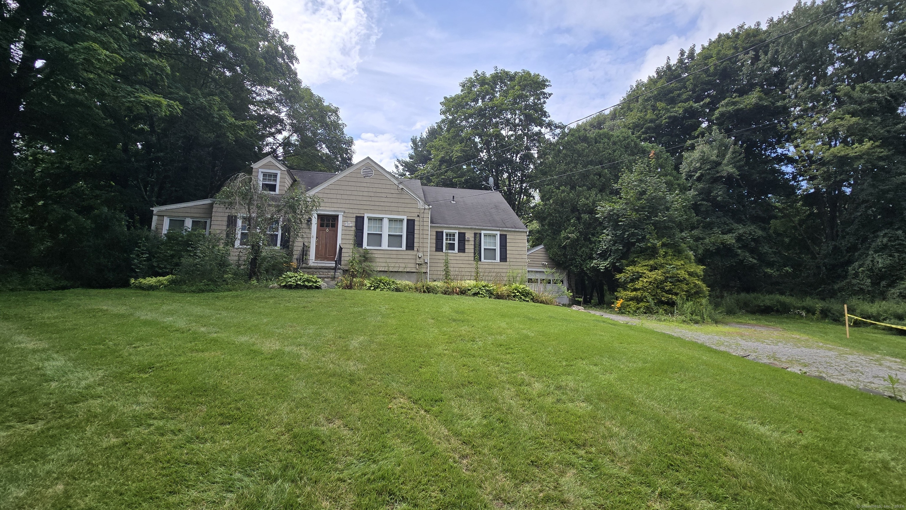 a front view of a house with a yard and trees