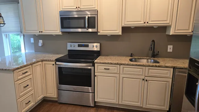 a kitchen with stainless steel appliances granite countertop a sink and a stove