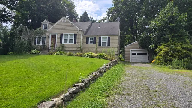 a front view of a house with a garden and yard