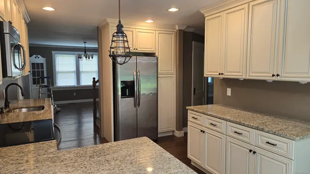 a kitchen with stainless steel appliances granite countertop a refrigerator and a sink
