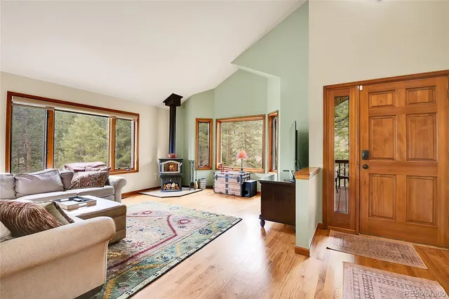 a living room with furniture large window and a wooden floor