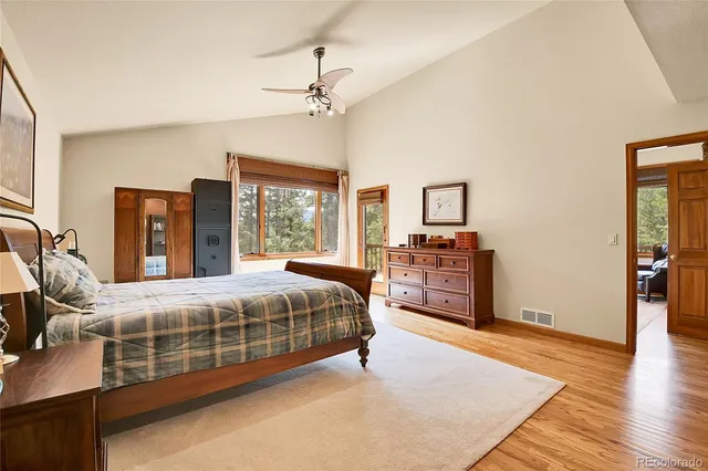 a bedroom with a large bed a chandelier and dresser