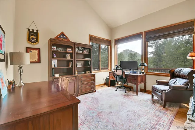 a view of a workspace with furniture and a large window