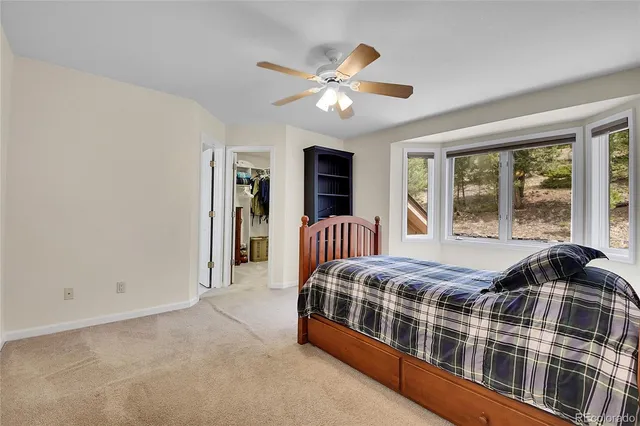 a bedroom with a bed next to a large window with a flat screen tv