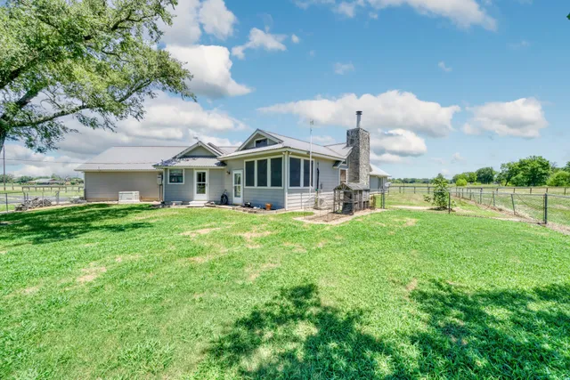 a view of a house with swimming pool next to a yard