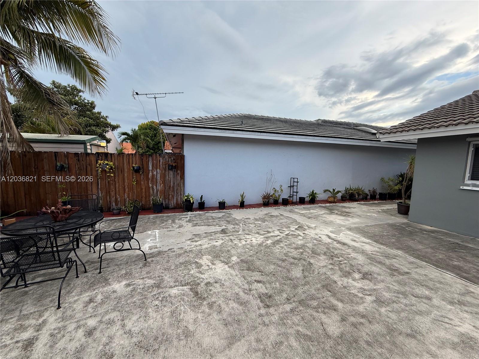 14770 Southwest 60th Street Miami, FL 33193 - Photo 3 of 16 a backyard of a house with table and chairs