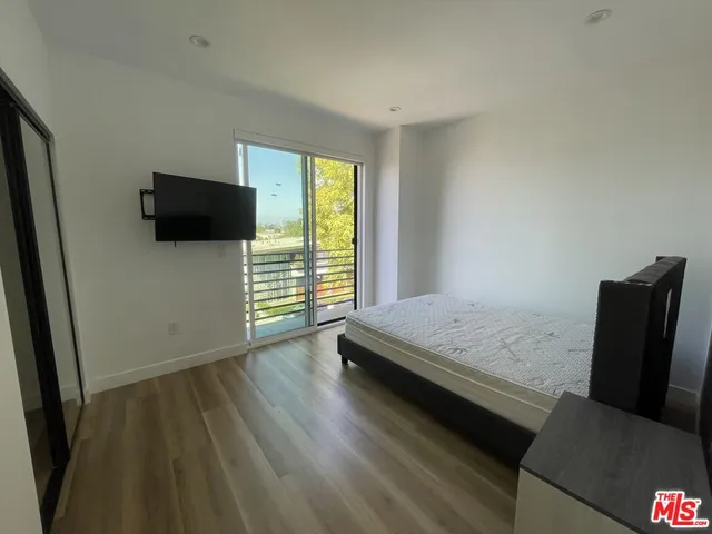 a bedroom with a bed and flat screen tv