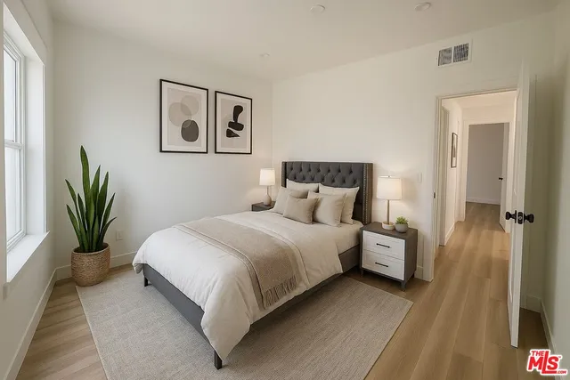 a bedroom with bed and a potted plant