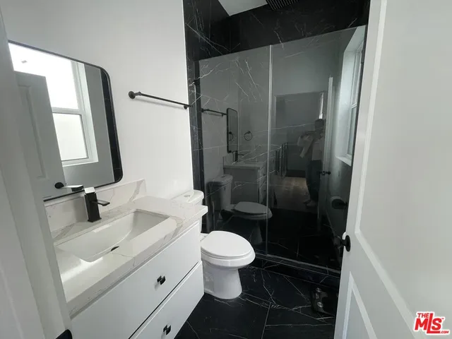 a bathroom with a sink a toilet and a mirror