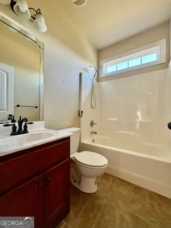 a bathroom with a sink a toilet a mirror a bathtub and shower