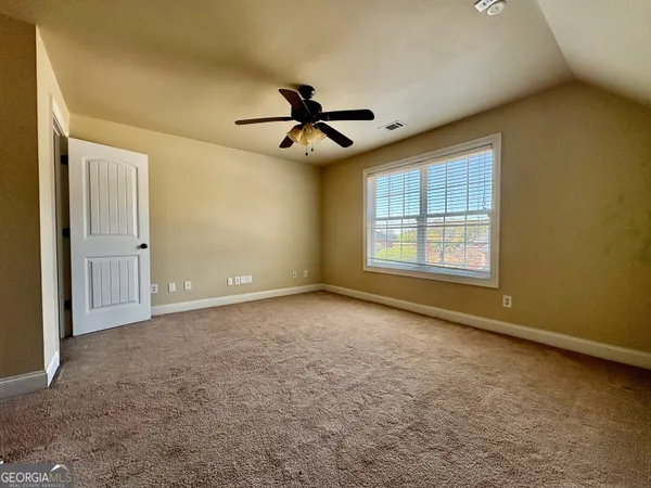 an empty room with windows and fan