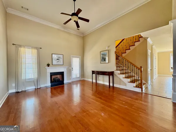 a view of an empty room with wooden floor fireplace and a window