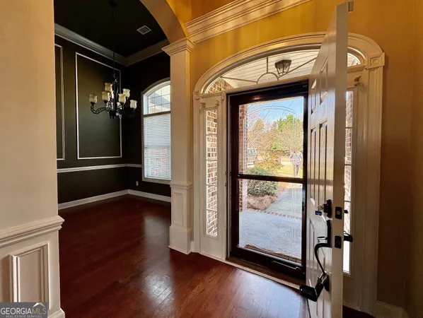 a view of a hallway with wooden floor and door