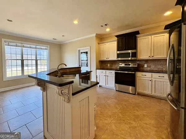 a kitchen with granite countertop a sink and cabinets
