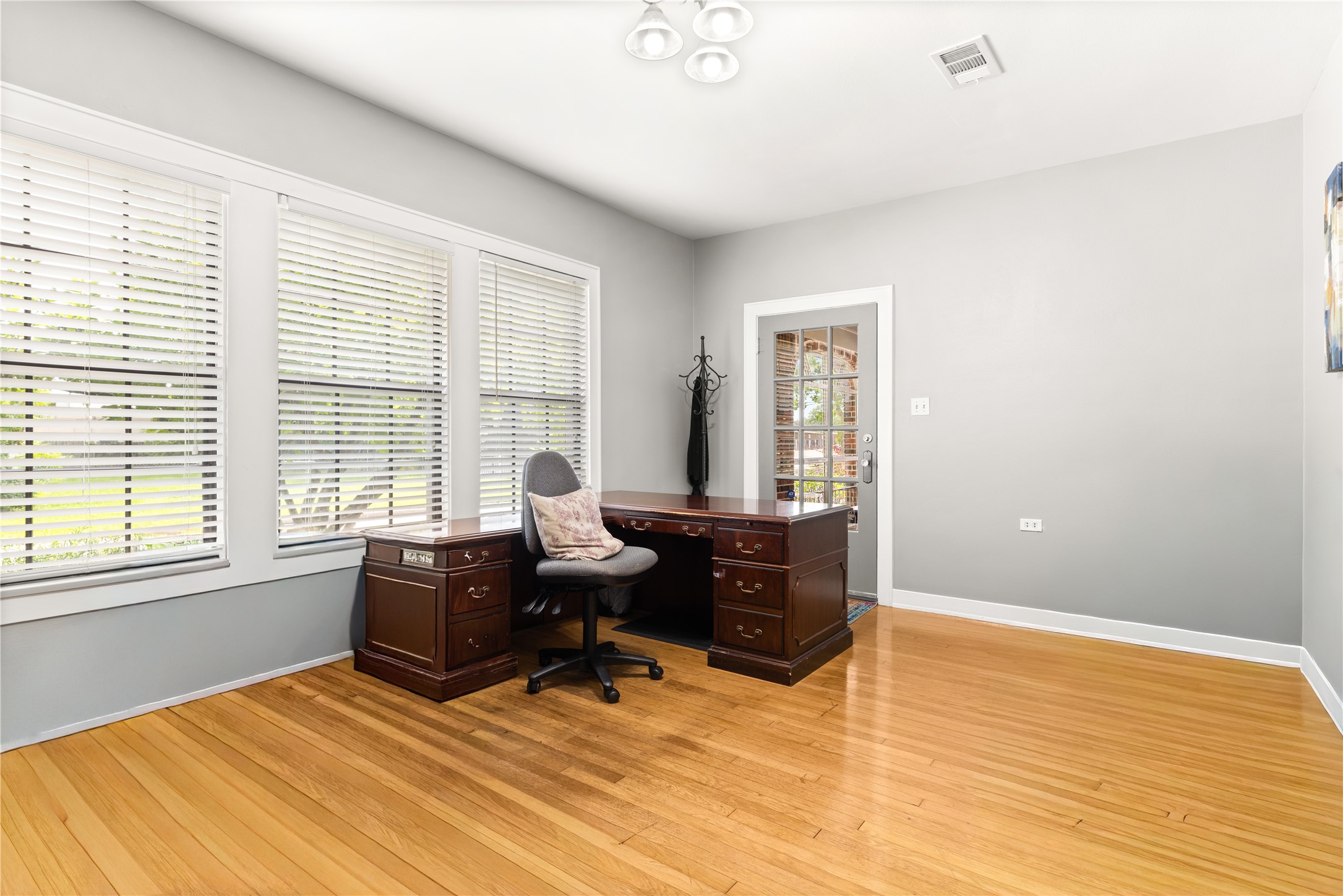 906 Higgins Street Humble, TX 77338 - Photo 16 of 26 This bright, spacious office features large windows, and wood flooring. A glass-paneled door offers additional natural light and access to adjacent areas.