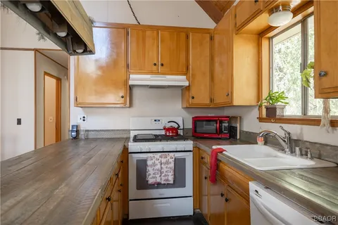 a kitchen with stainless steel appliances granite countertop a sink a stove and cabinets