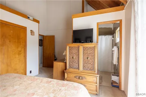 a bedroom with a bed and a large mirror on the dresser