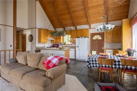 a living room with furniture a chandelier and kitchen view