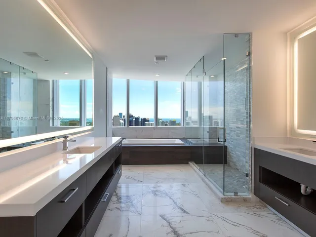 a bathroom with a large tub sink and double vanity