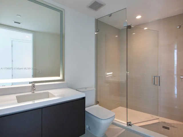 a bathroom with a double vanity sink toilet and shower