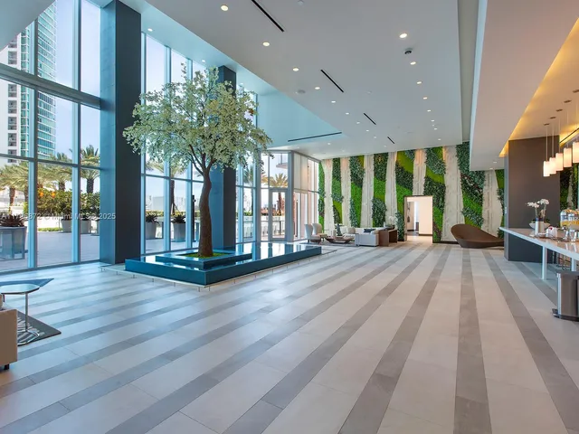 an empty room with floor to ceiling windows and potted plants