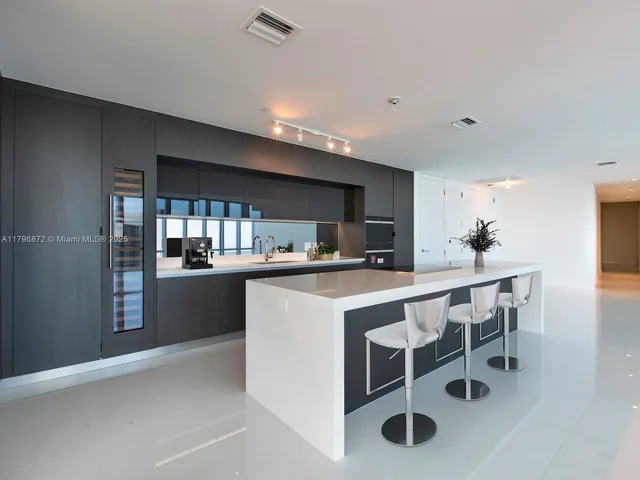 a kitchen with a table chairs sink and cabinets
