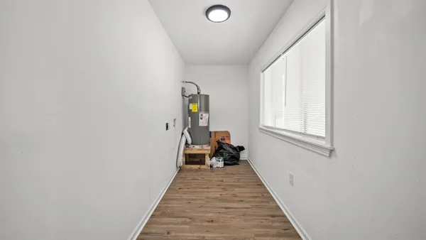 a view of a bedroom with wooden floor and a window
