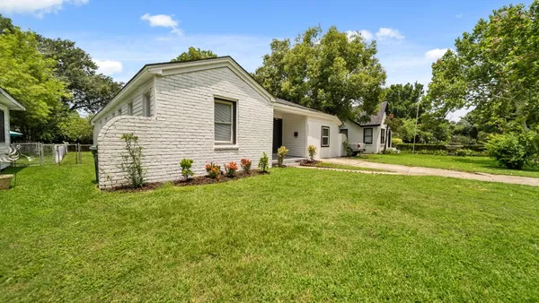 a front view of house with yard and trees