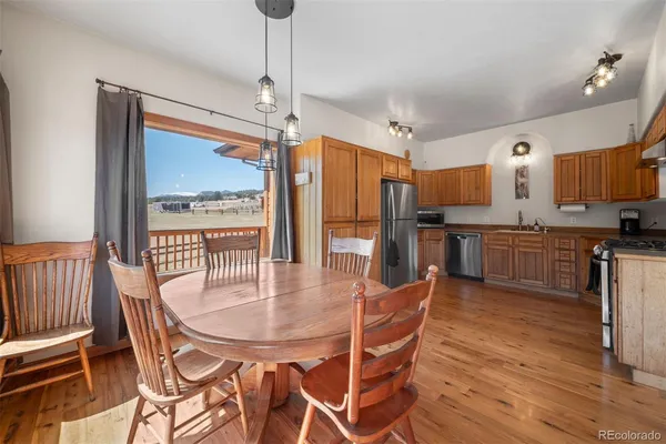 a dining room with stainless steel appliances a table chairs refrigerator and kitchen view