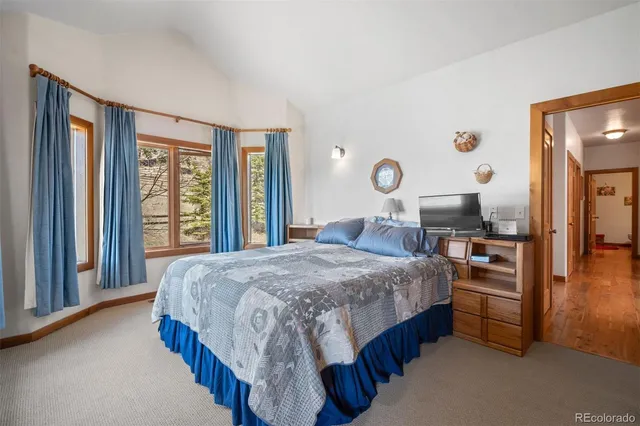 a bedroom with a bed and a large window