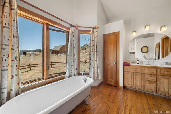 a bathroom with a granite countertop tub sink a mirror and a shower