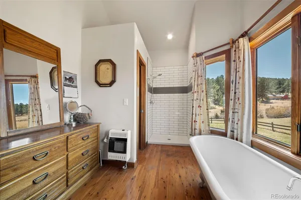 a spacious bathroom with a granite countertop tub and a large window