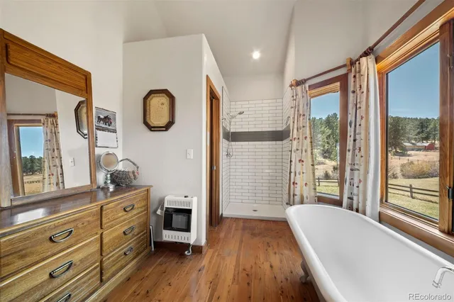 a spacious bathroom with a granite countertop tub and a large window
