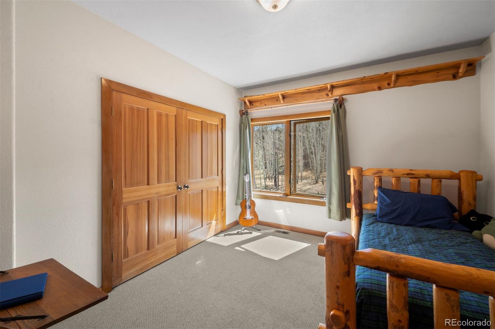1740 County Road 72 Bailey, CO 80421 - Photo 19 of 40 a bedroom with furniture and a window