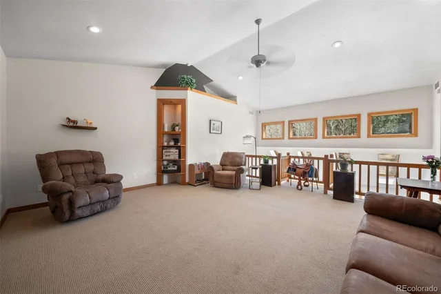 a living room with furniture and a ceiling fan