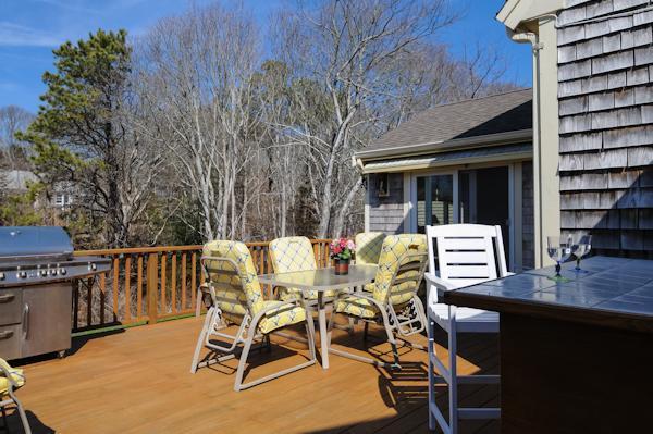 141 Elliott Road Centerville, MA 02632 - Photo 4 of 17 a view of a patio with table and chairs with wooden floor and fence