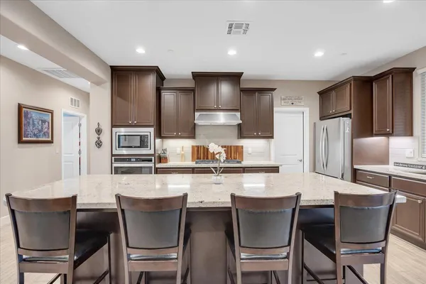 a cabinet in a kitchen with stainless steel appliances toys and wooden floor
