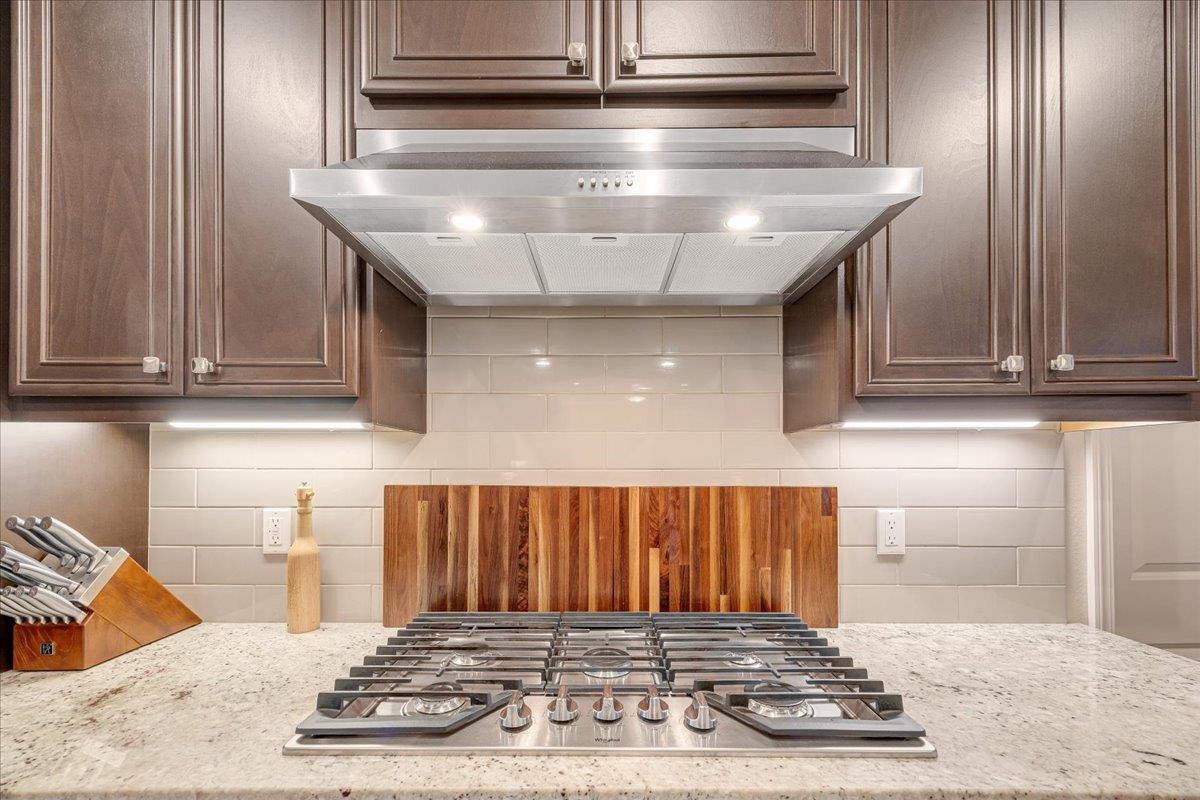 133 Palisades Place Copperopolis, CA 95228 - Photo 18 of 89 5-burner gas range with hood for whipping up feasts. Under-cabinet lighting illuminates the space.