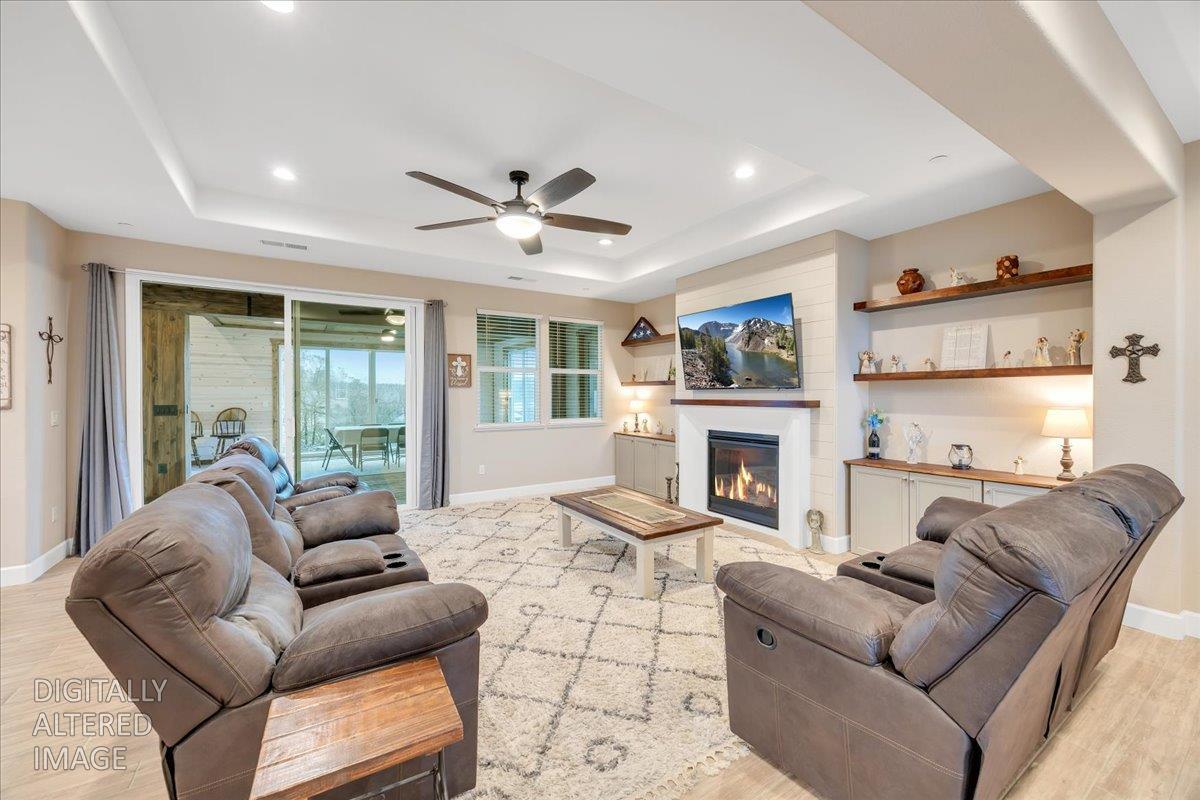 133 Palisades Place Copperopolis, CA 95228 - Photo 10 of 89 Enter to an inviting living room, featuring wood-look tile plank flooring throughout all the high-traffic areas and a cozy fireplace with shiplap surround and custom shelving. Fireplace fire added in editing. Fireplace does work per sellers, just wasn't on for the shoot.