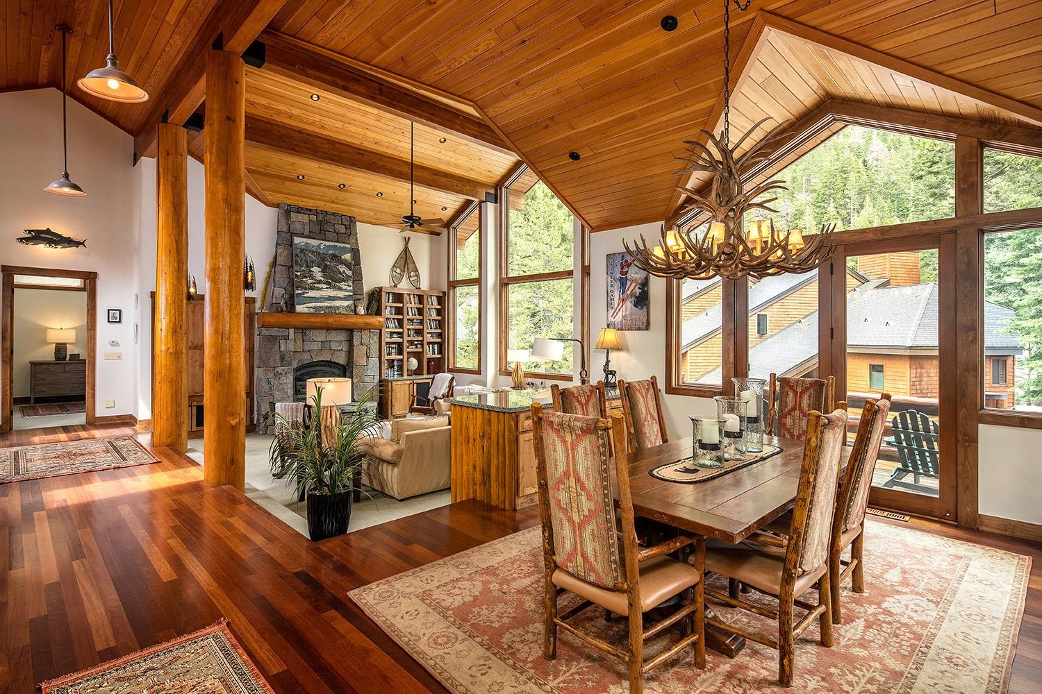 135 Alpine Meadows Road, Unit 33 Alpine Meadows, CA 96145 - Photo 2 of 21 a dining room with wooden floor a chandelier a glass table and chairs