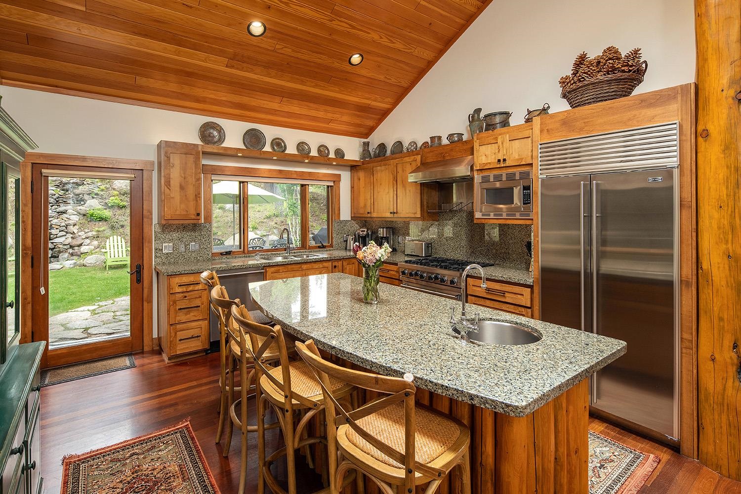 135 Alpine Meadows Road, Unit 33 Alpine Meadows, CA 96145 - Photo 6 of 21 a kitchen with stainless steel appliances granite countertop a stove a refrigerator a dining table and chairs with wooden floor