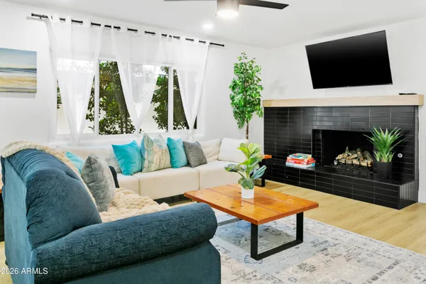 a living room with furniture a flat screen tv and a fireplace