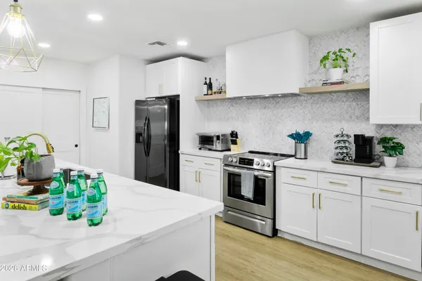 a kitchen with stainless steel appliances granite countertop a white refrigerator a stove a sink and dishwasher