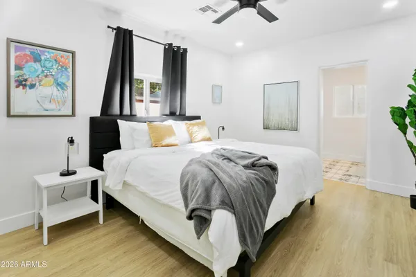 a bedroom with a bed and wooden floor