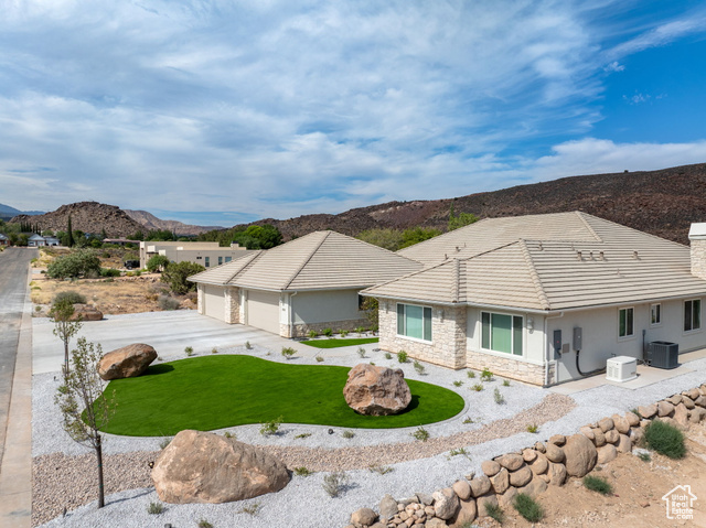 230 Boulder Way Leeds, UT 84746 - Photo 45 of 72 View of front of home featuring stone siding, a mountain view, stucco siding, concrete driveway, and a chimney, Low E Windows