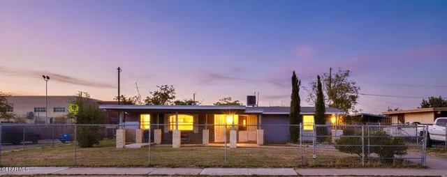 a view of a house with a patio and a yard