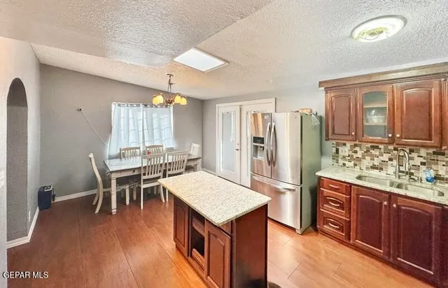 a kitchen with a wooden floor and chairs