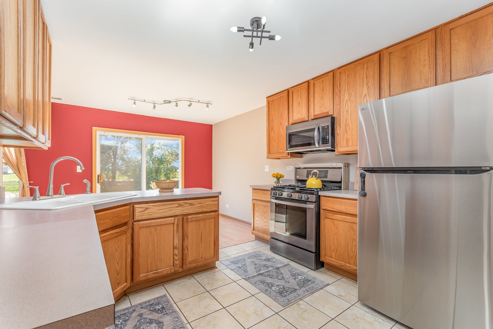 16043 Tiger Drive Lockport, IL 60441 - Photo 5 of 22 a kitchen with granite countertop a refrigerator stove top oven and sink